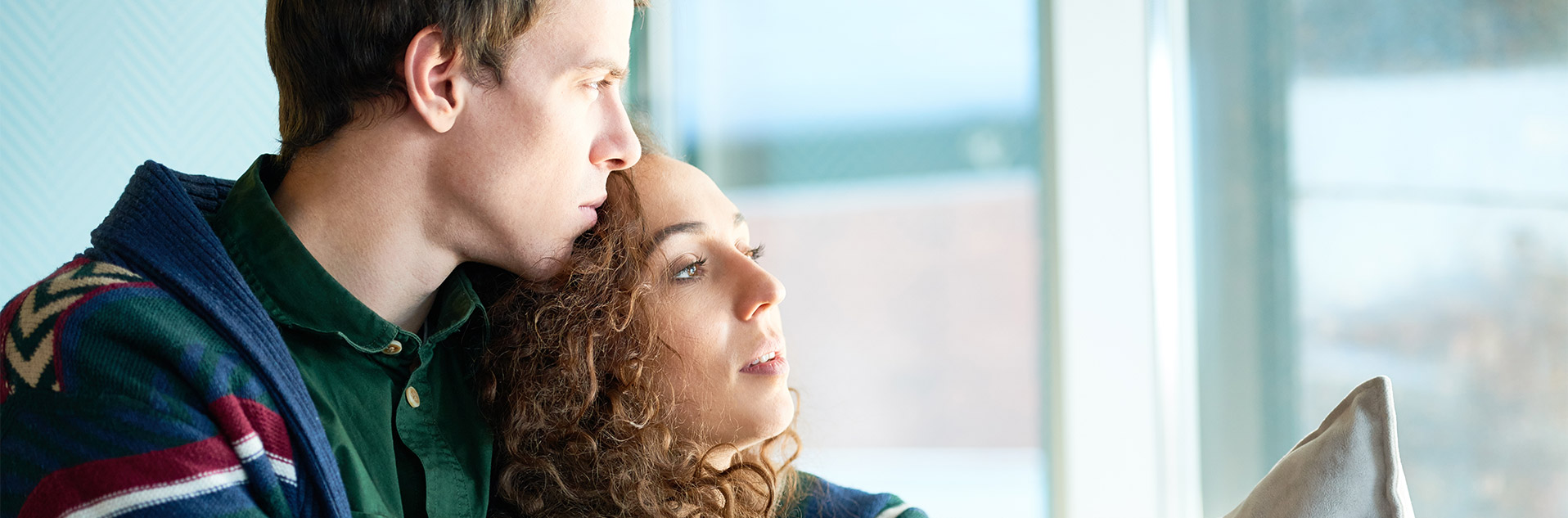 couple in serious thought looking out a window