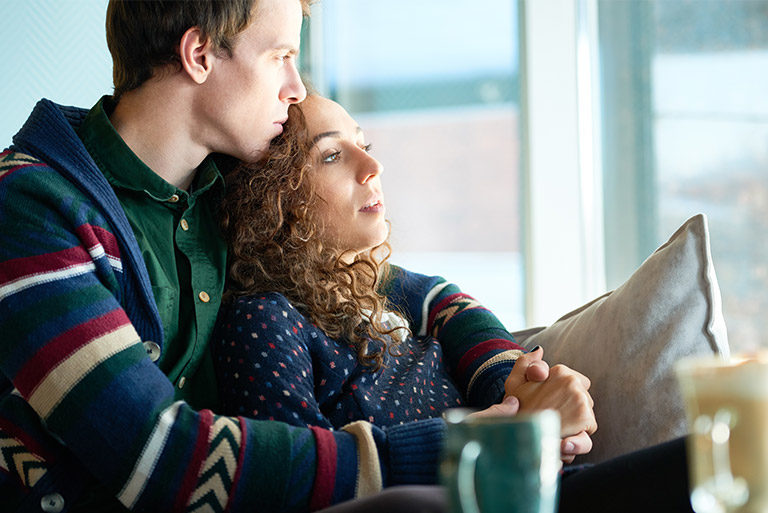 Couple in thought looking out window