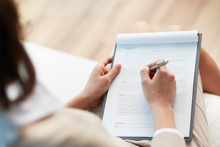 filling out forms with a pen on a clipboard